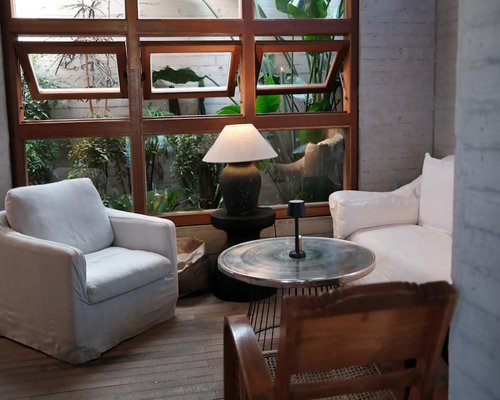 Soft light coming through window curtains illuminating an organized living room reading area